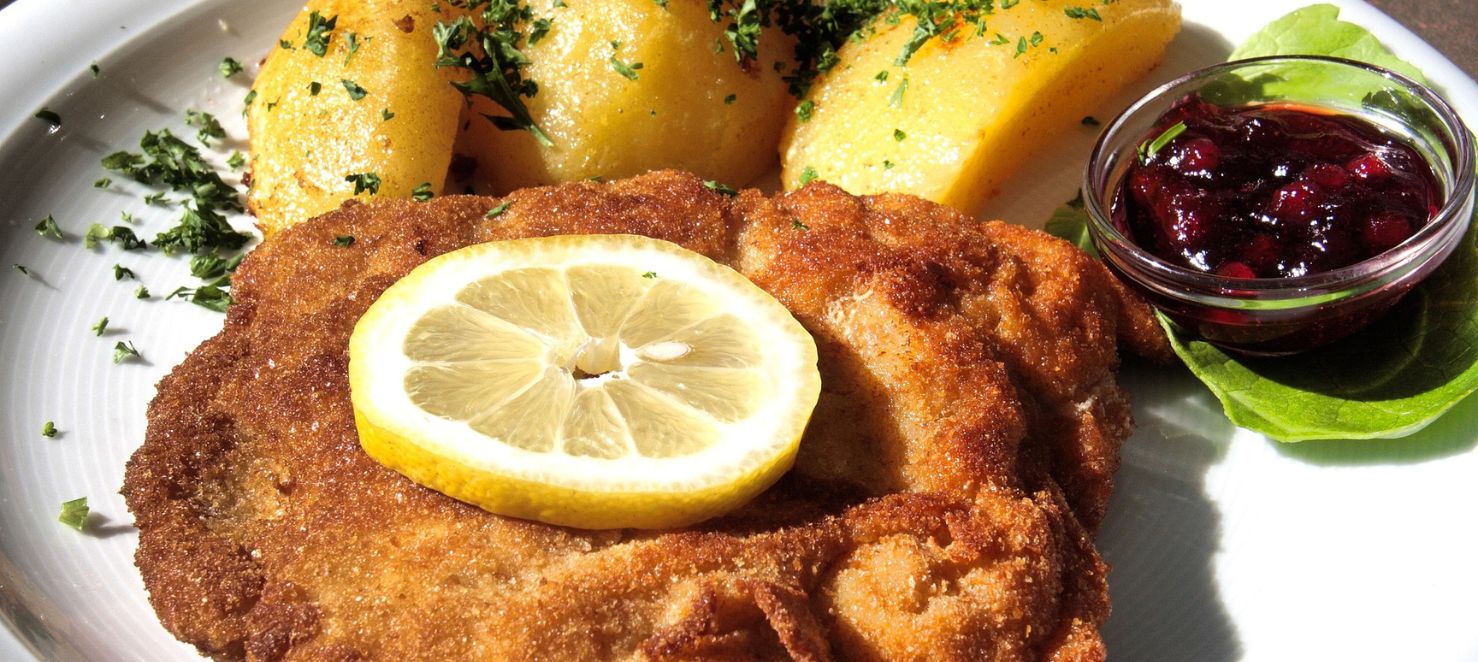 Schnitzel mit Petersilkartoffel, Zitronenscheibe und Preiselbeeren