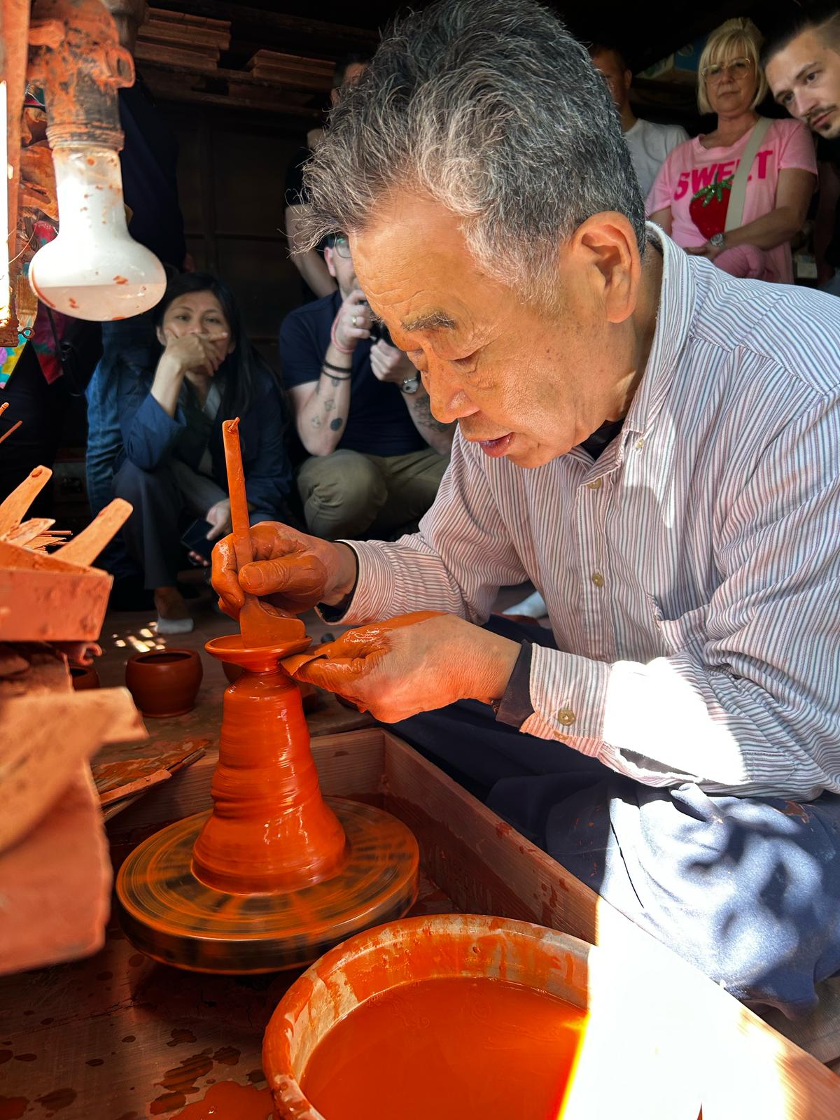 Kyusu live – Töpferkunst in Japan zum Anfassen nah Japanischer Keramiker demonstriert an der Töpferscheibe die Herstellung einer Kyusu-Kanne – umgeben von aufmerksamem Publikum