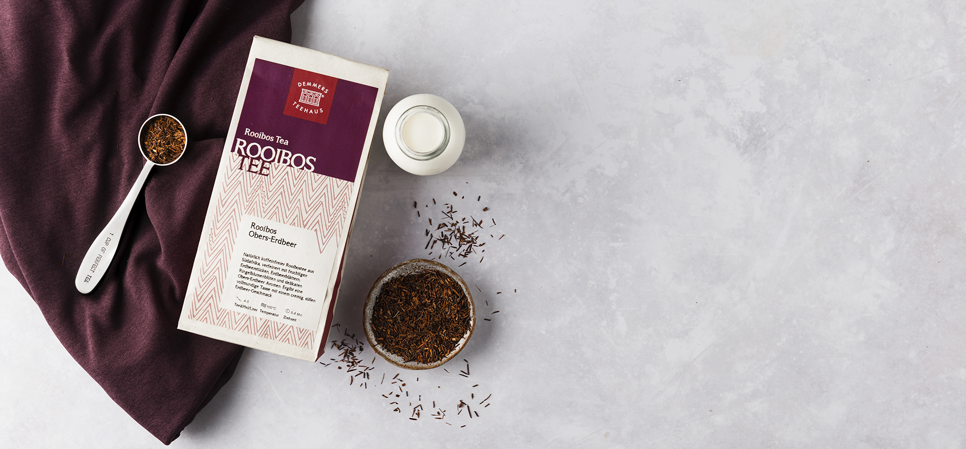 Demmers Teehaus Rooibos Tee Rooibos Obers-Erdbeer verpackt mit Löffel, losem Tee und Milchfläschchen