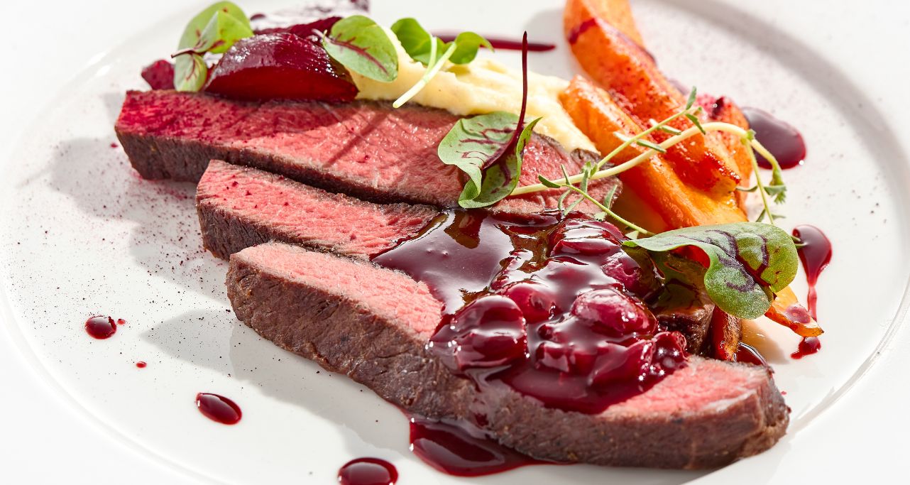 Filetsteak  schön angerichtet mit Karoten, Salat und Kirschsauce