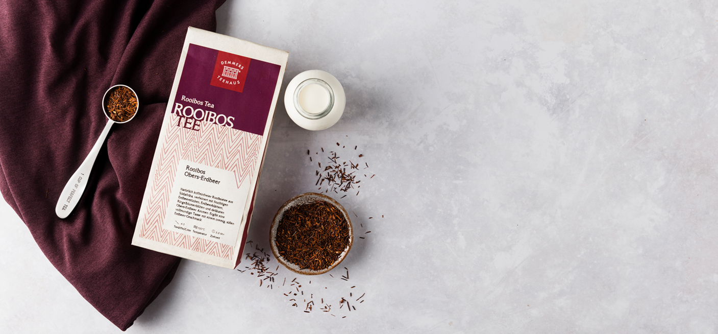 Demmers Teehaus Rooibos Tee Rooibos Obers-Erdbeer verpackt mit Löffel, losem Tee und Milchfläschchen